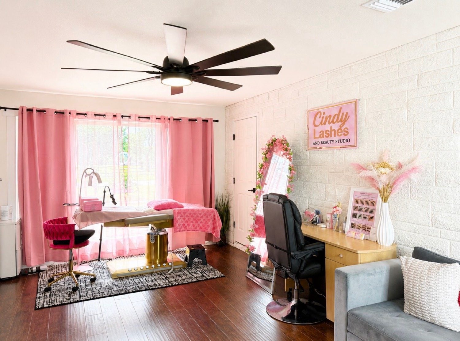 Treatment bed, pink curtains, and the Cindy Lashes sign
